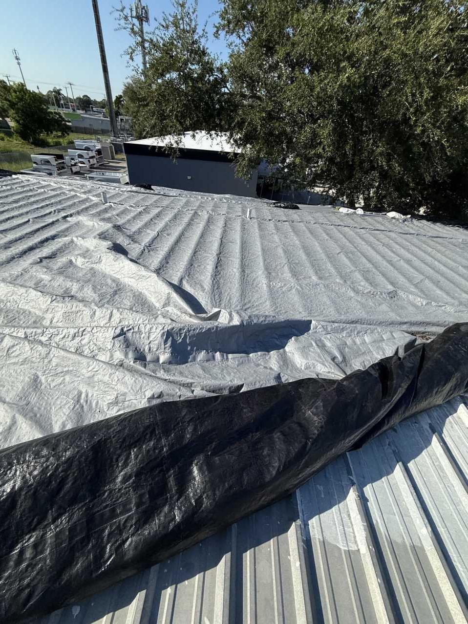 Hotel roof partially covered with tarp during emergency roof tarping
