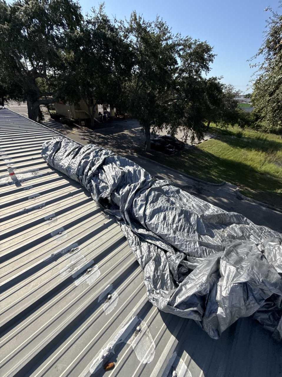 Heavy-duty tarps staged and rolled on a hotel roof before deployment