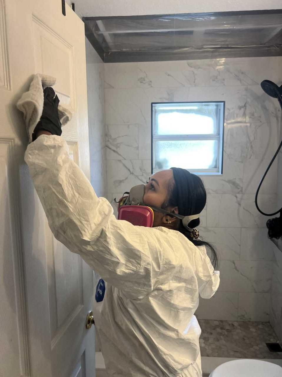 RFS technician wiping down a bathroom door frame during cleanup