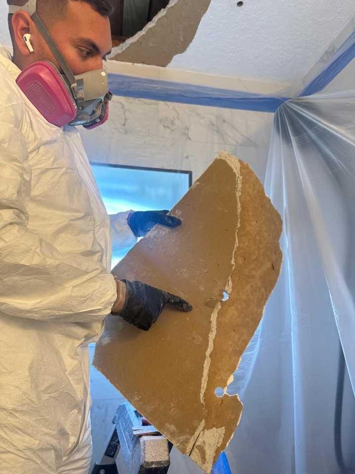 RFS technician removing water-damaged ceiling drywall
