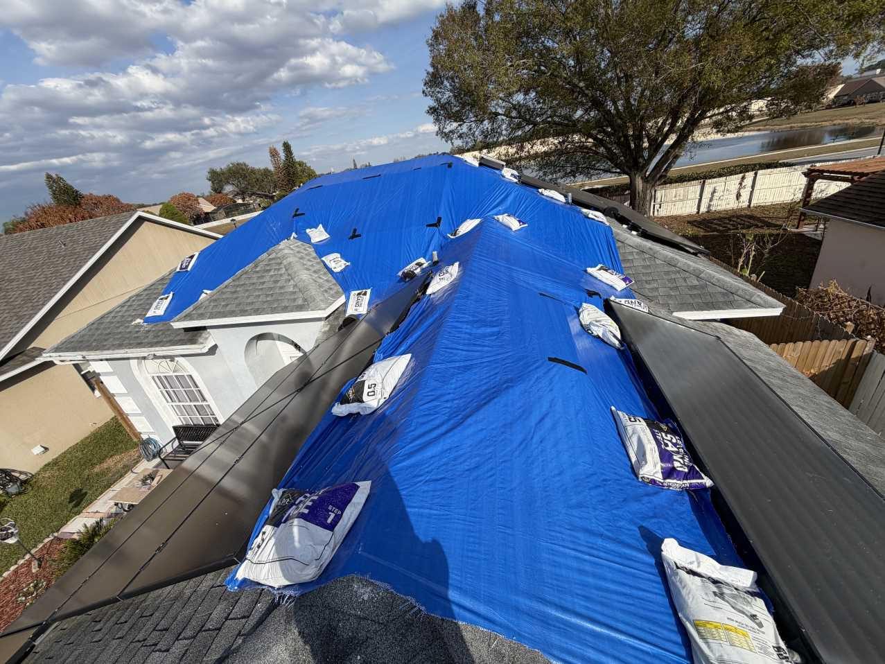 RFS crew securing a tarp on a storm-damaged roof