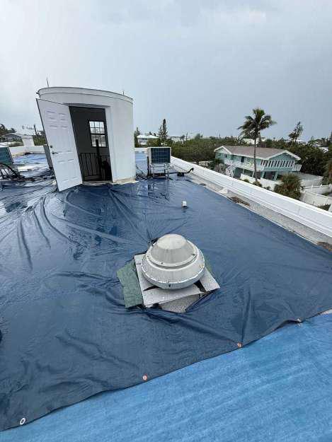 Commercial flat roof fully secured with heavy-duty tarps after emergency roof tarping service