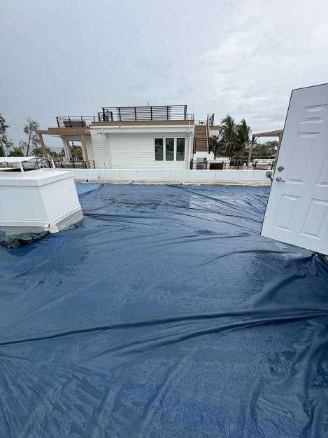 Commercial roof nearly fully covered with tarps during emergency tarping service