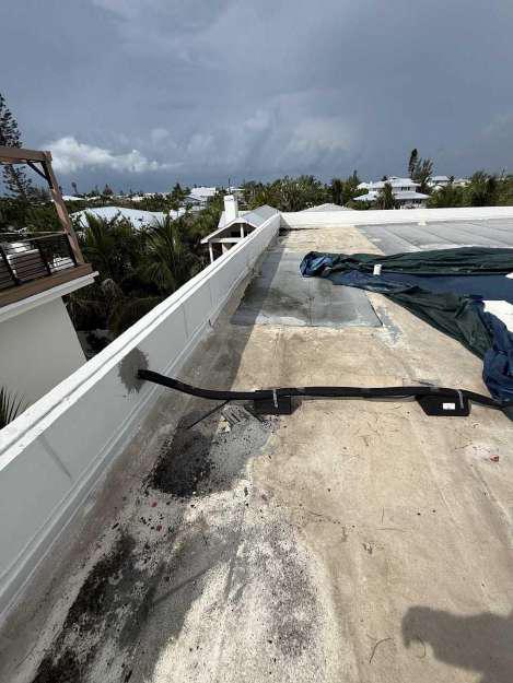 Storm clouds approaching over a Florida commercial roof during emergency tarping