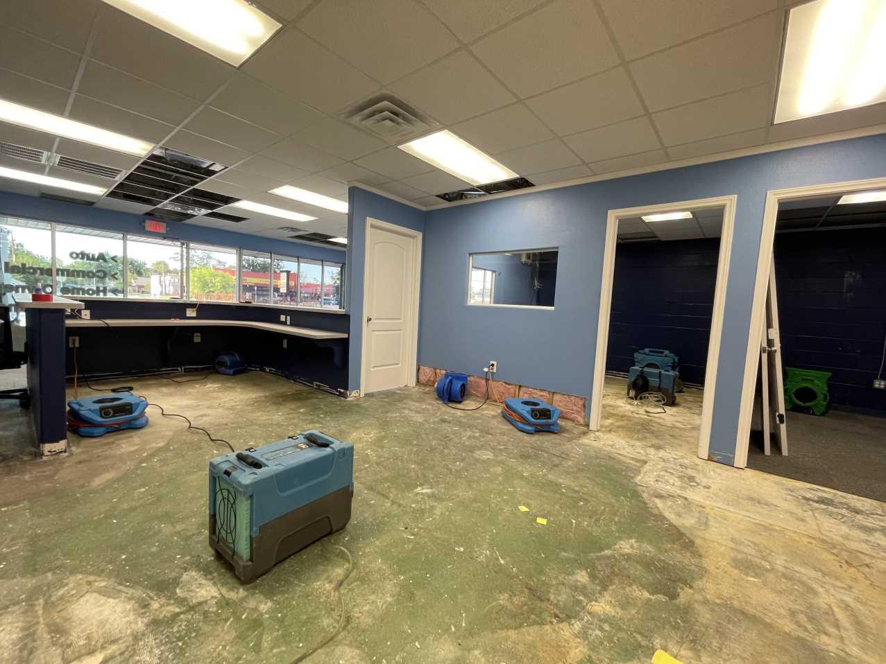 Air movers and dehumidifiers drying a commercial office after storm damage