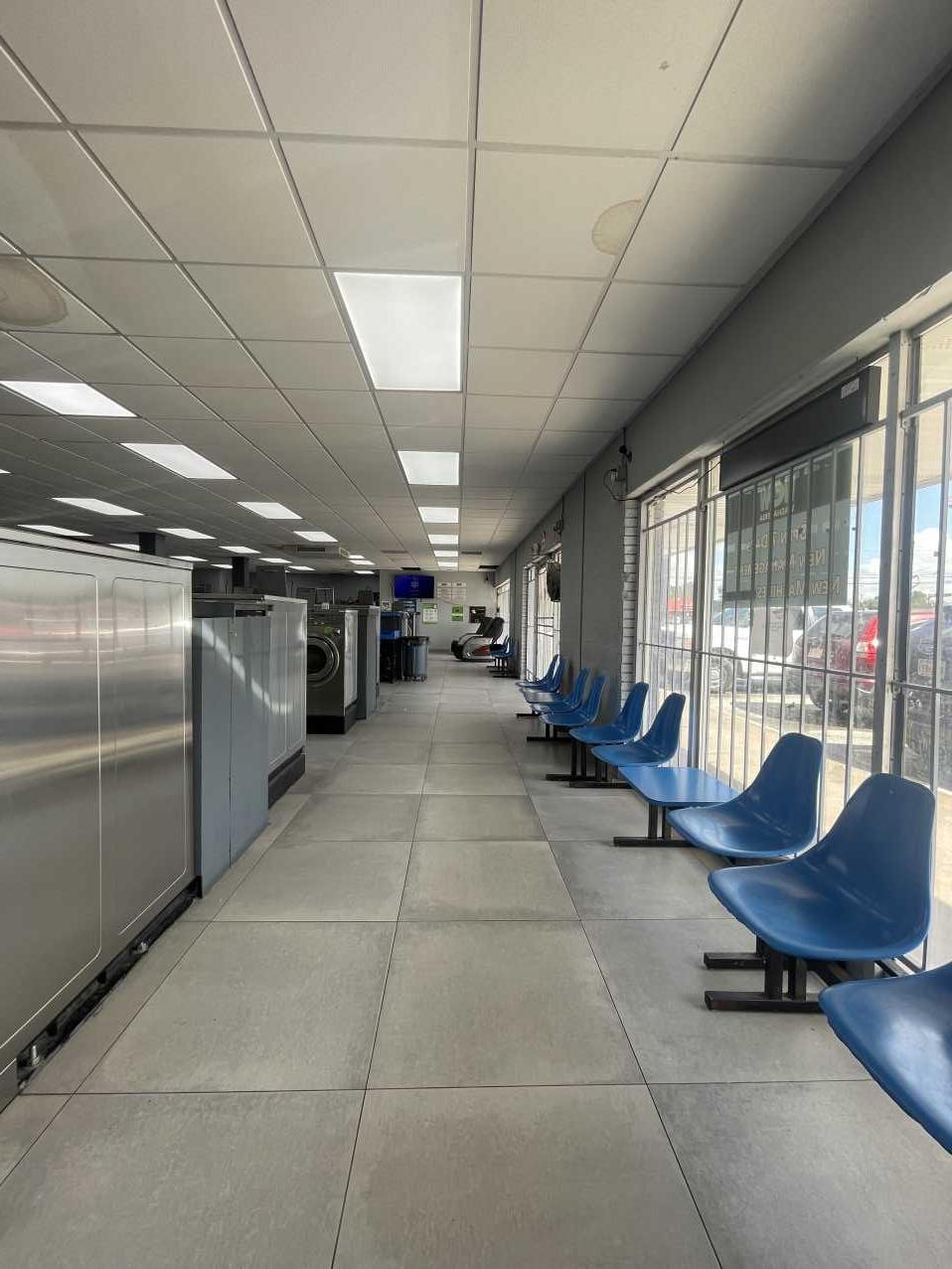 Commercial laundromat interior before water damage, rows of washers and dryers