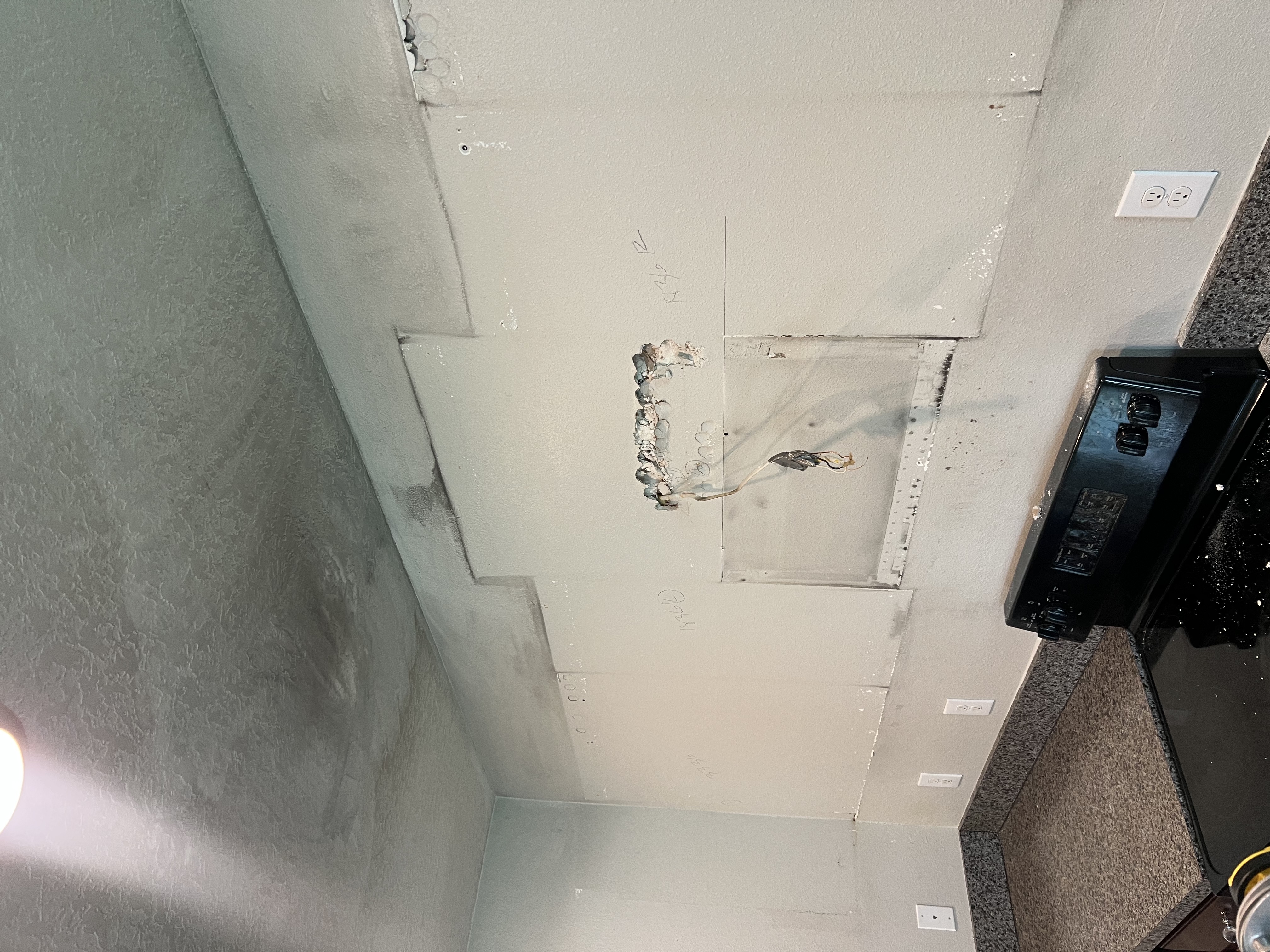 Close-up of fire and smoke damage on a kitchen ceiling and electrical outlet