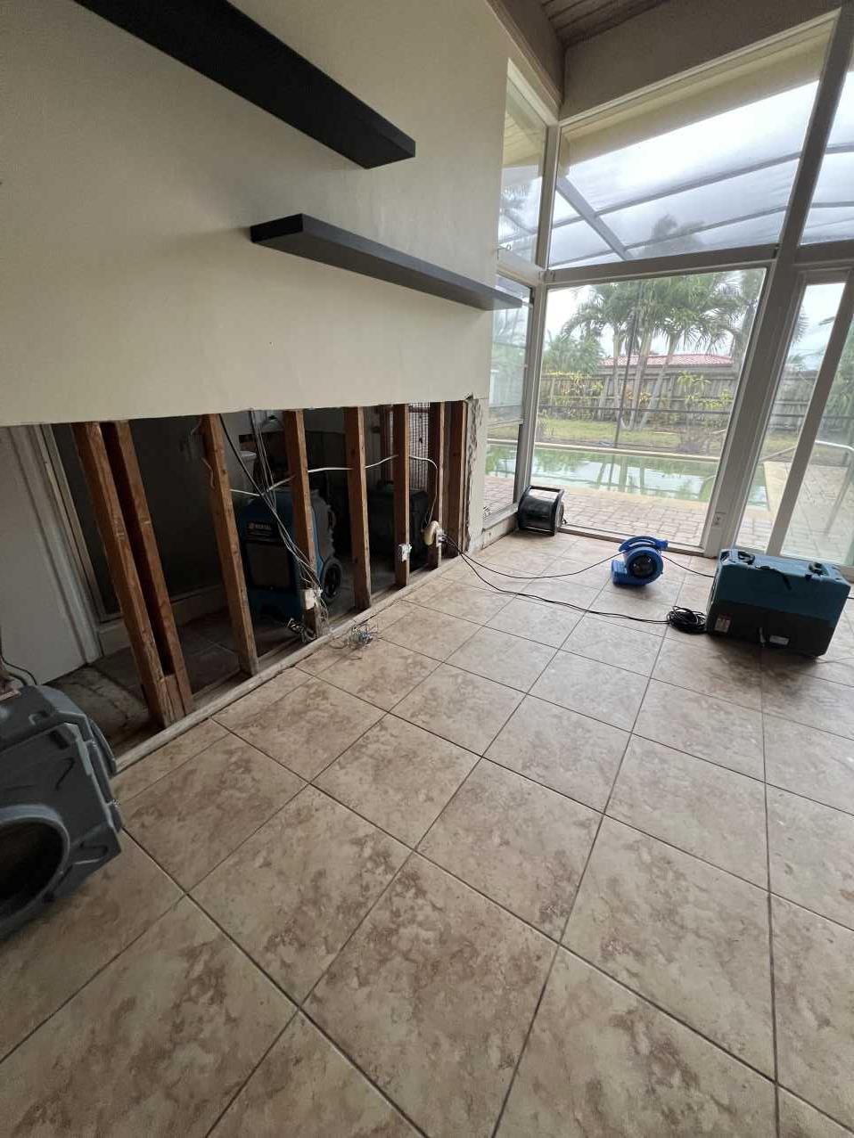 Drying equipment running in a sunroom after Hurricane Helene flood damage
