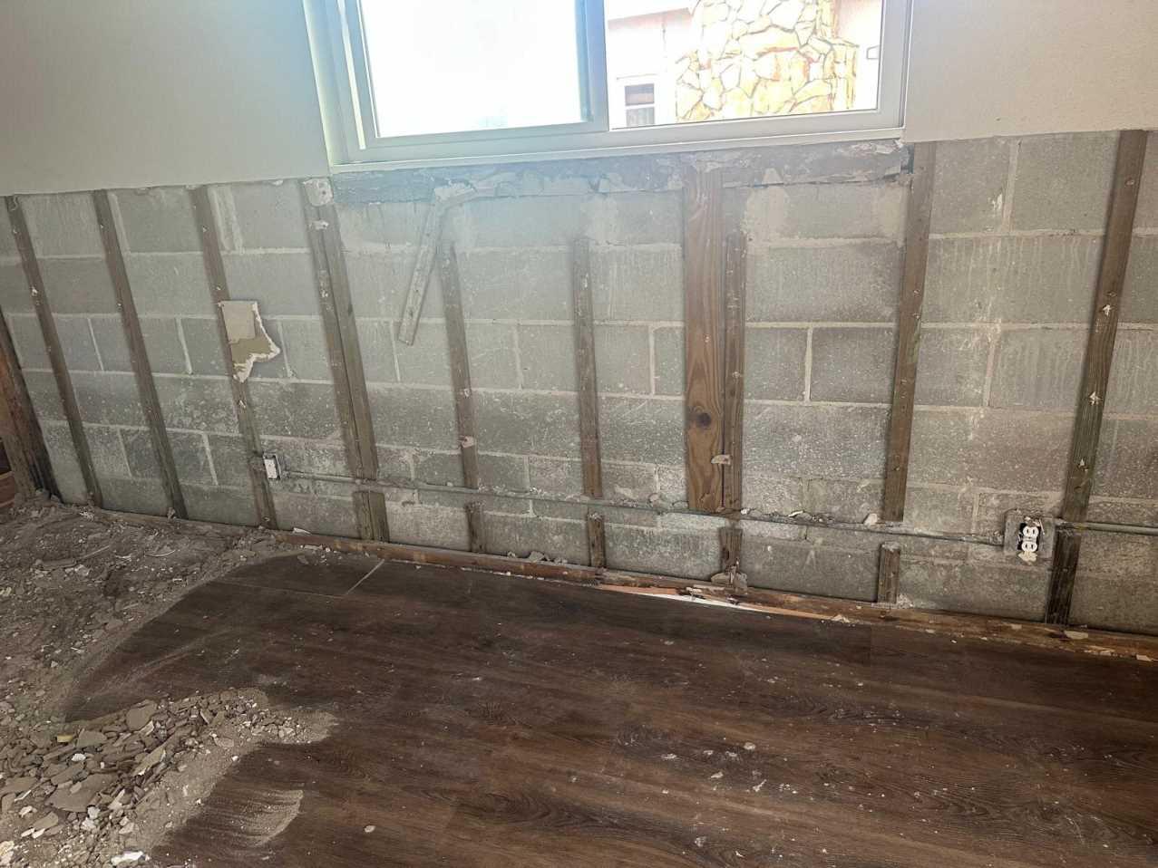 Wall opened up in a flood cut revealing block wall and studs after Hurricane Helene