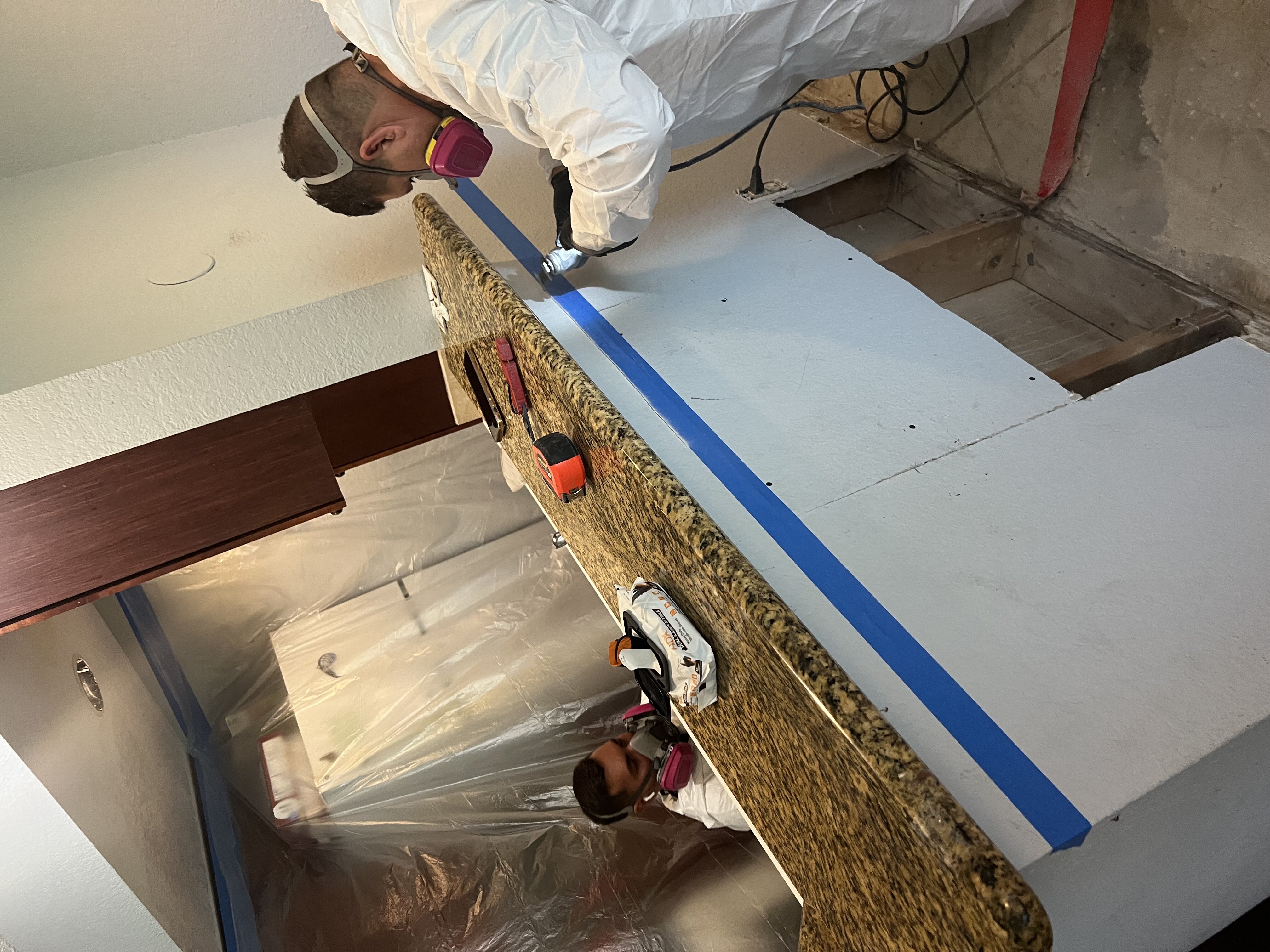 Restoration crew members sealing containment barriers during mold remediation