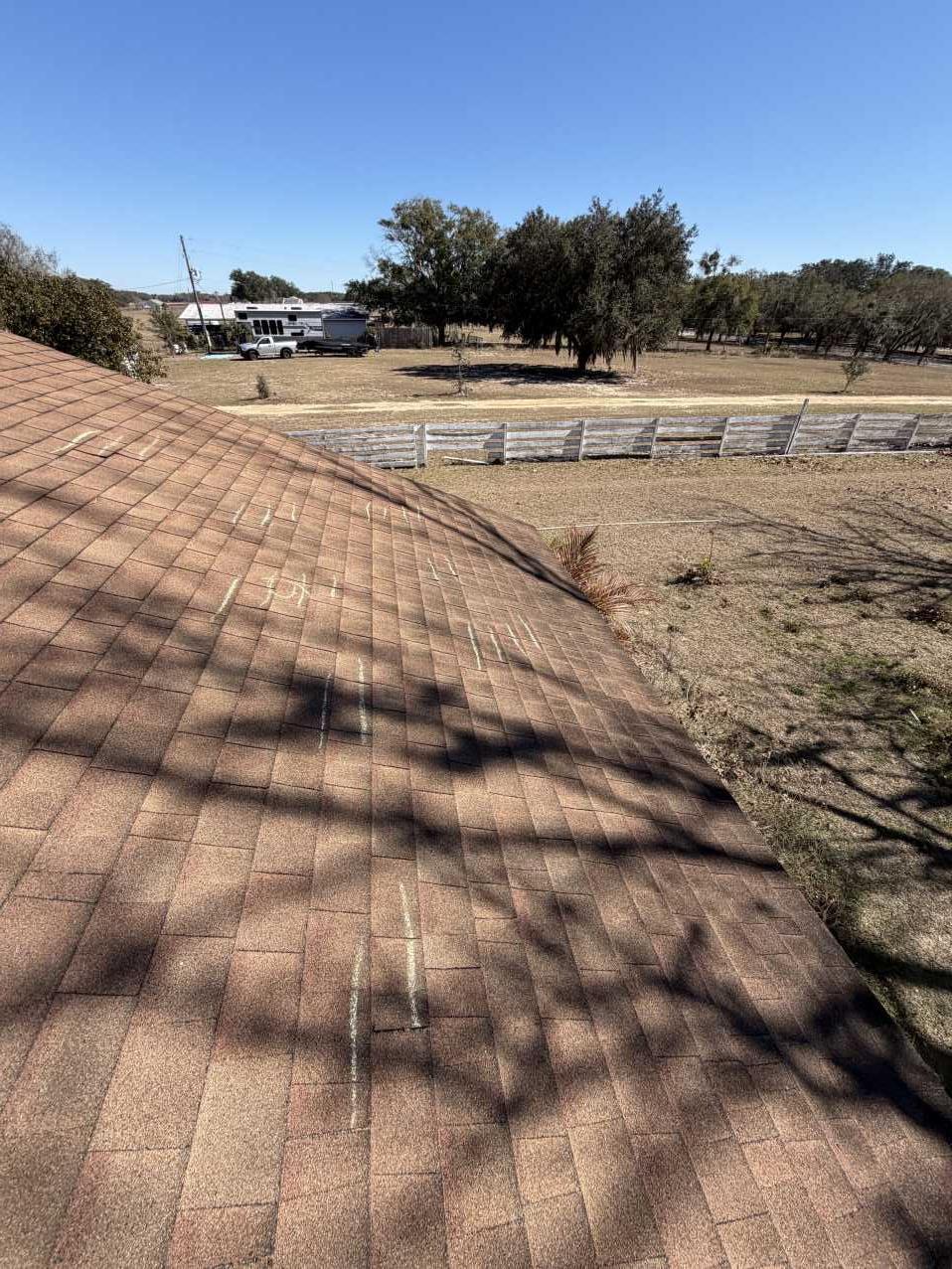 Chalk marks along a roof ridge documenting storm damage points