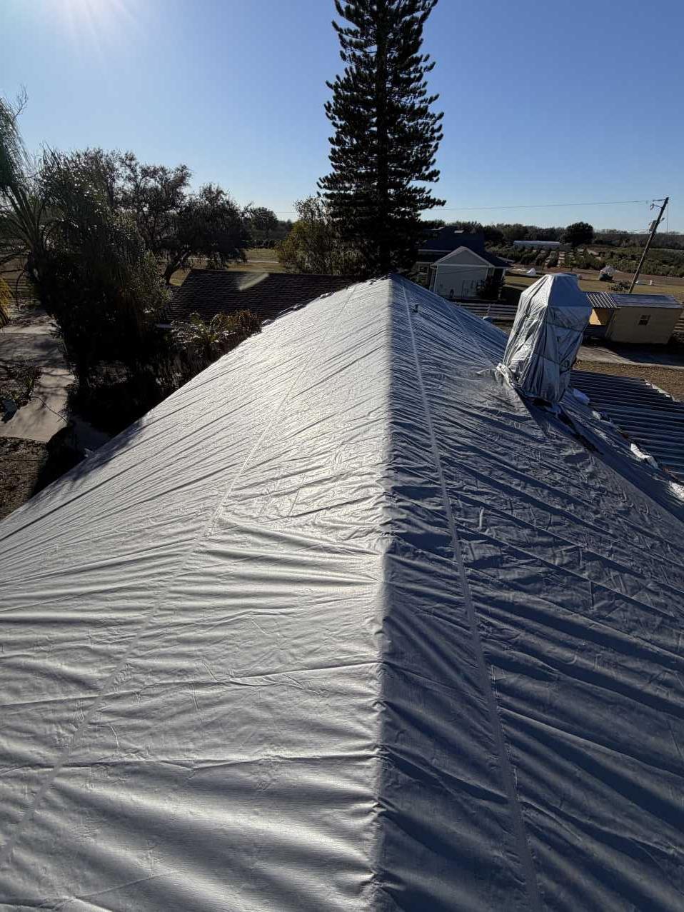 Fully secured roof tarp covering a storm-damaged Florida home