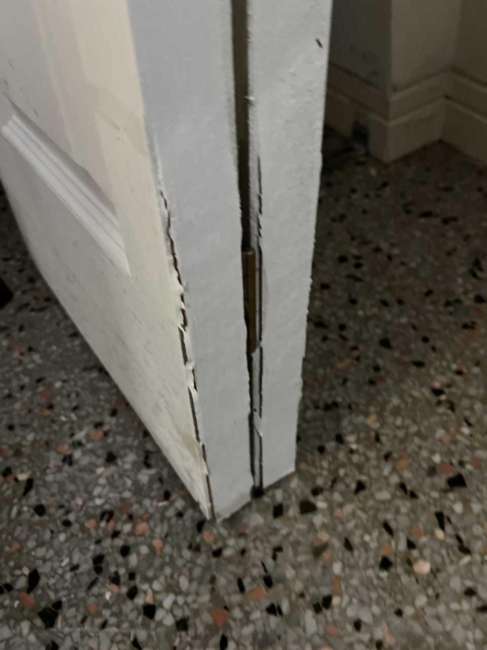 Close-up of a swollen, damaged door frame from storm water intrusion