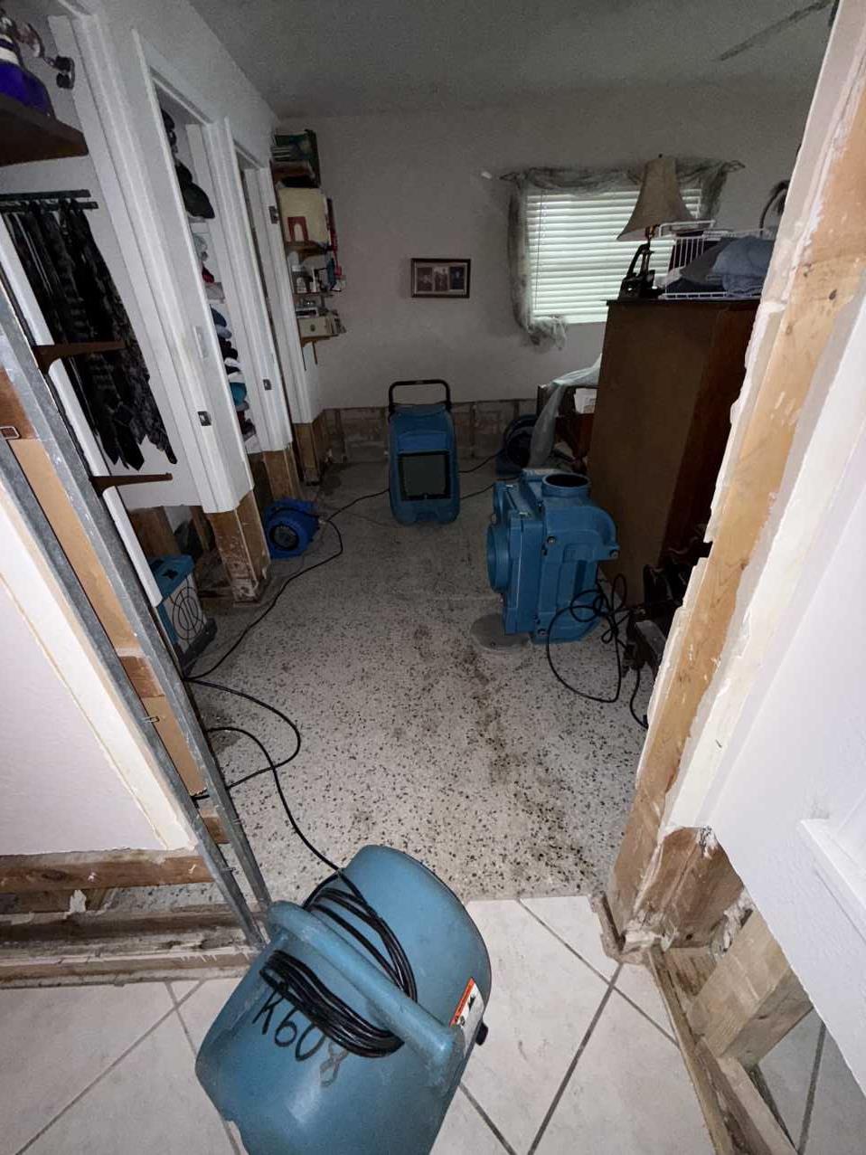 Bedroom and closet area with flood cut drywall and drying equipment running
