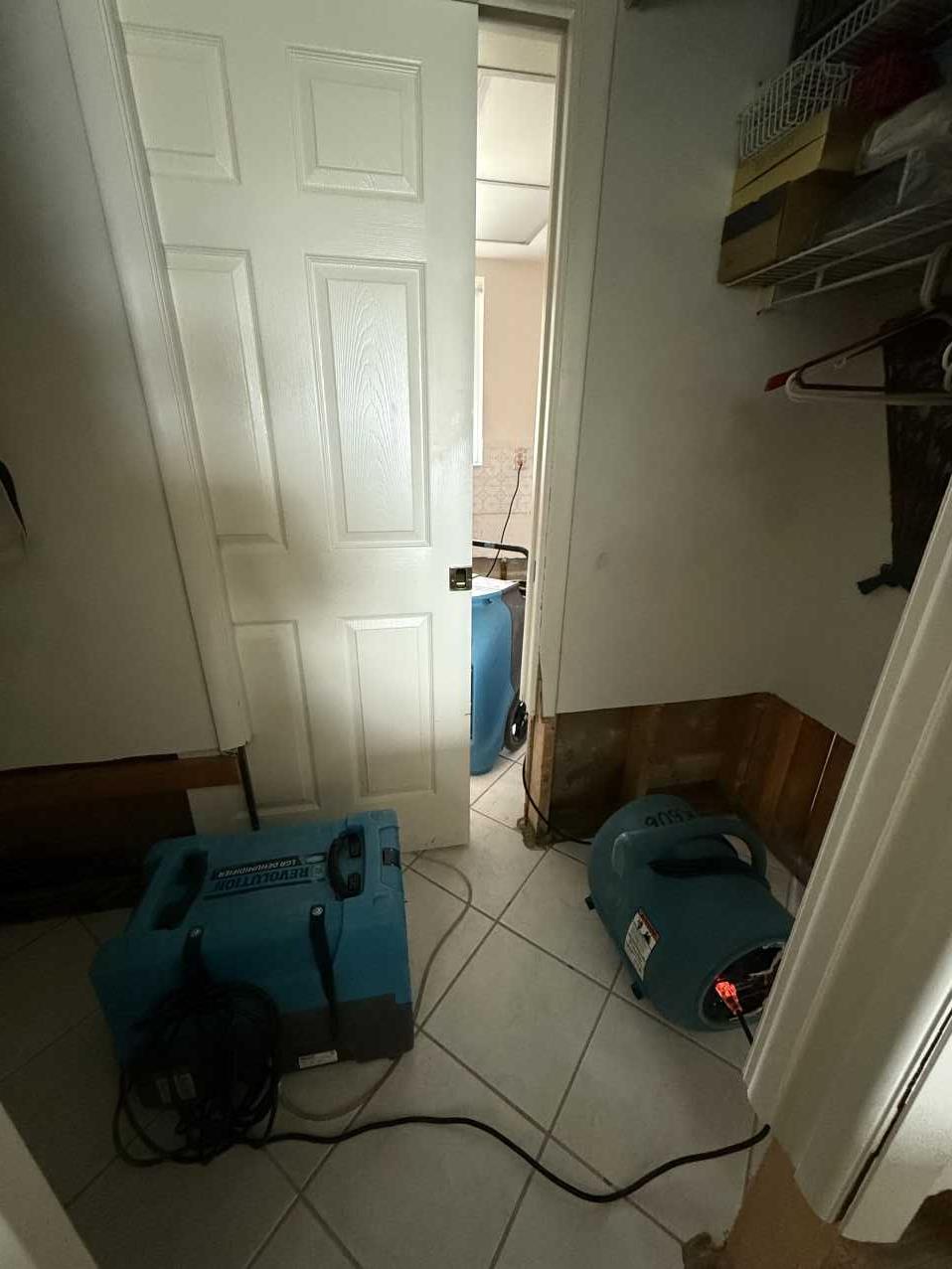 Flood cut drywall in a closet area with air movers and a dehumidifier running