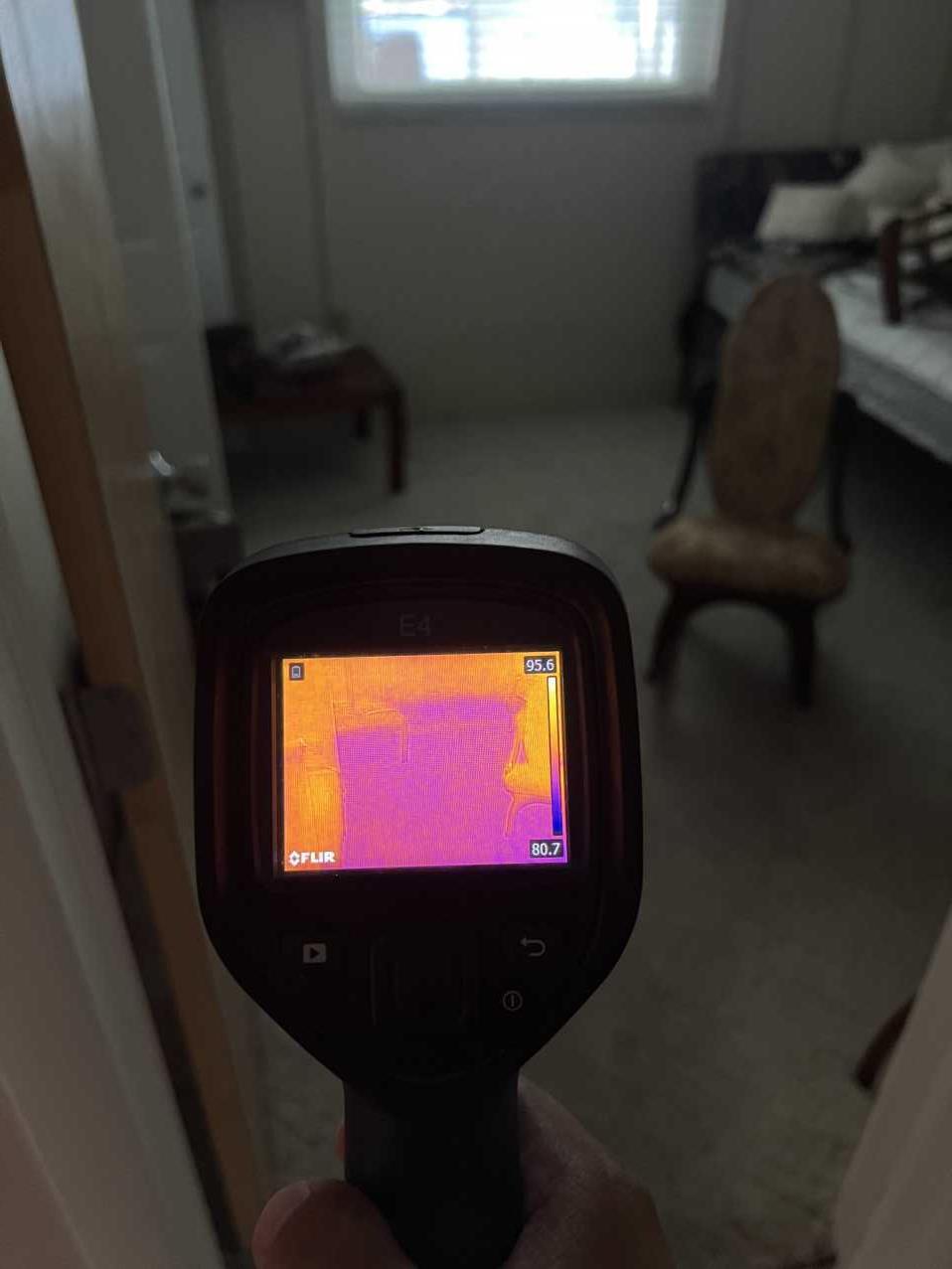 Restoration technician using a thermal imaging camera to inspect storm water intrusion