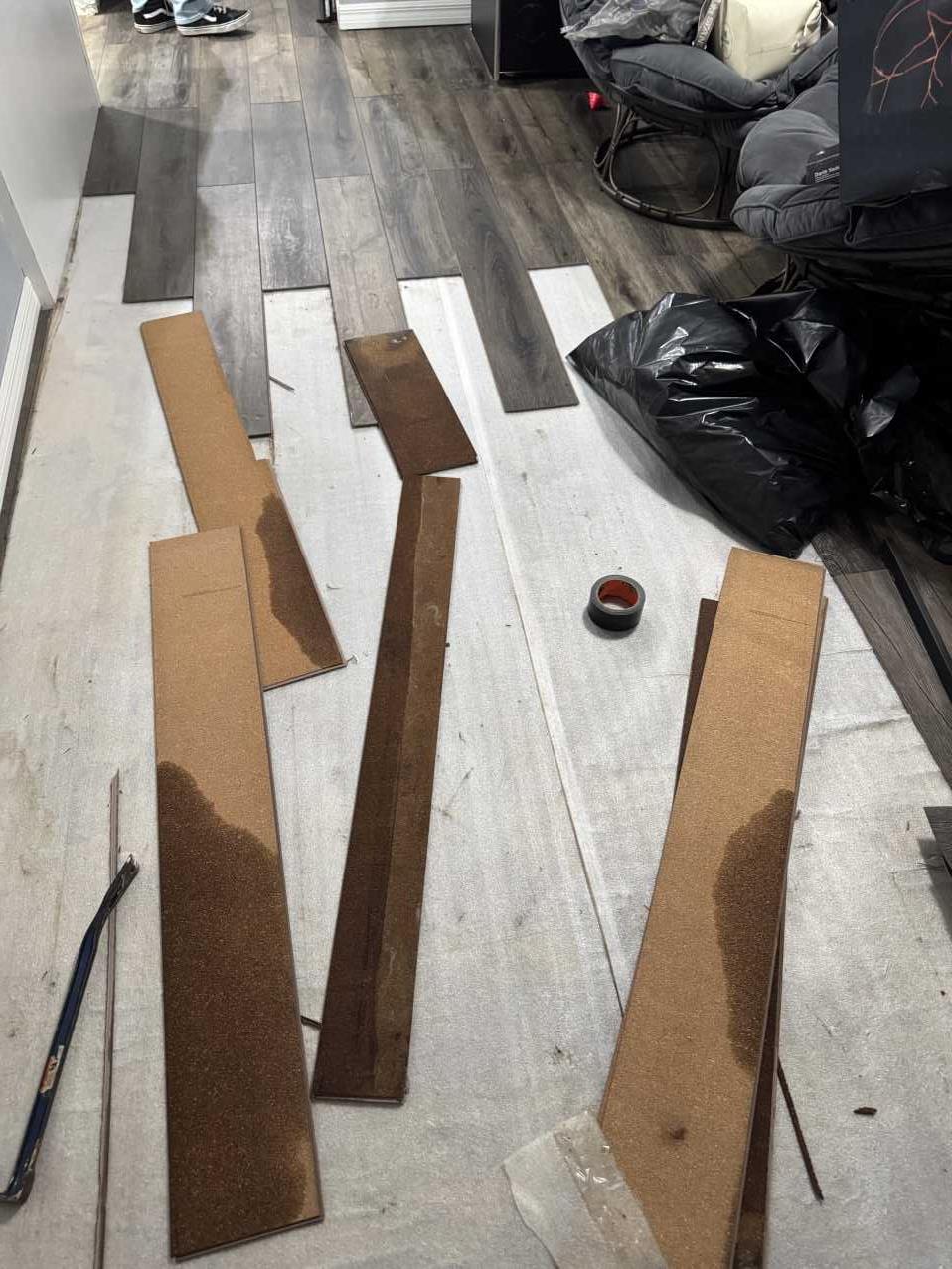 Water-damaged vinyl plank flooring removed during residential water damage restoration
